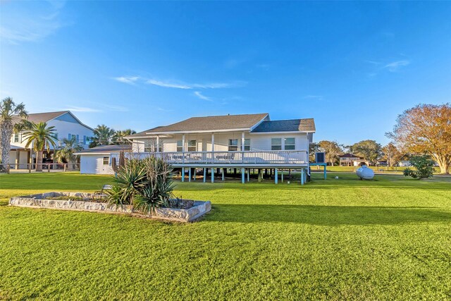 back of property with a lawn and a deck