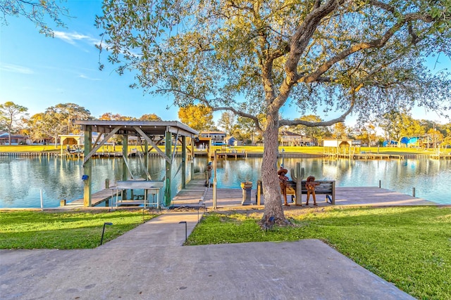 dock area with a water view and a lawn