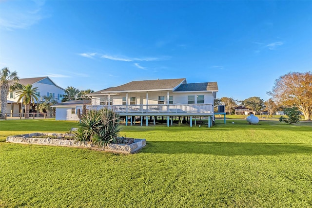 rear view of property with a deck and a lawn