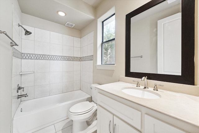 full bathroom with tile patterned flooring, vanity, tiled shower / bath combo, and toilet