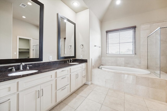 bathroom with tile patterned flooring, vanity, vaulted ceiling, and shower with separate bathtub