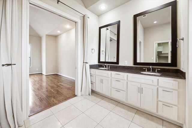 bathroom featuring tile patterned flooring, vanity, and lofted ceiling