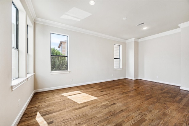 spare room featuring hardwood / wood-style flooring, ornamental molding, and a wealth of natural light