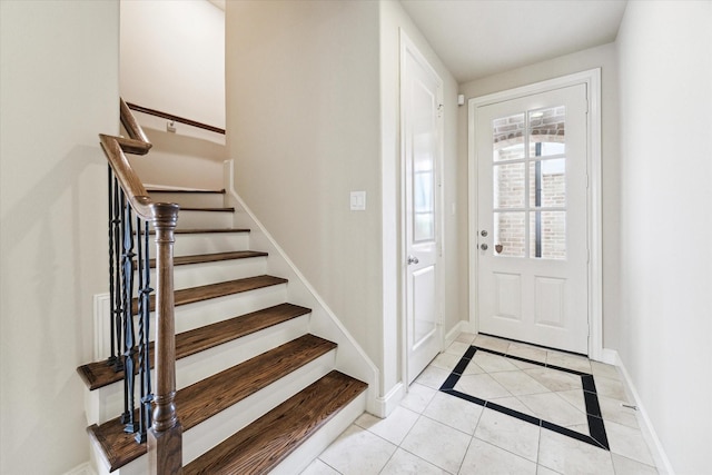 entryway with light tile patterned floors, stairway, and baseboards