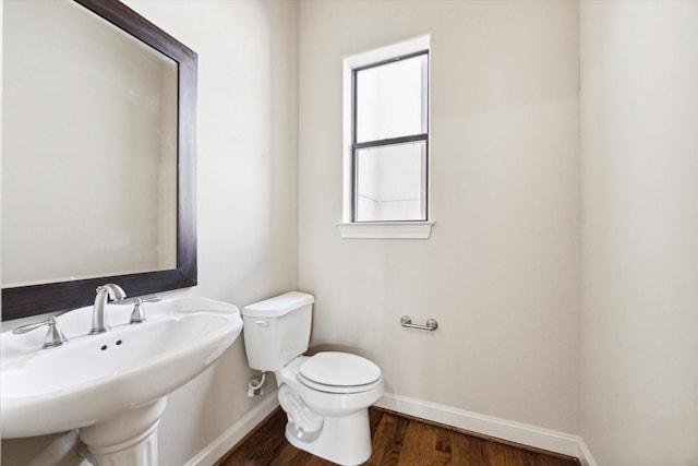 bathroom with wood-type flooring, toilet, and sink