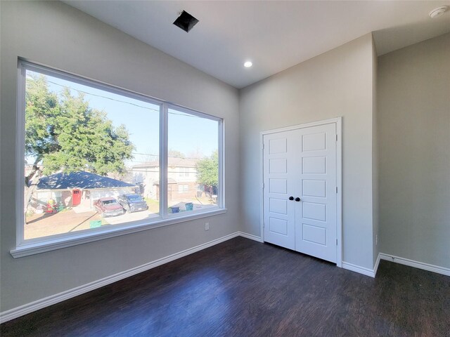 unfurnished bedroom featuring a closet and dark wood-type flooring