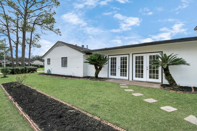 rear view of house featuring a yard and french doors