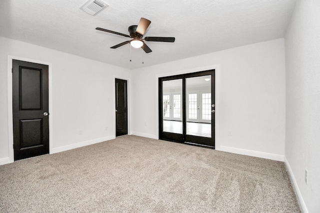 carpeted empty room with ceiling fan and a textured ceiling