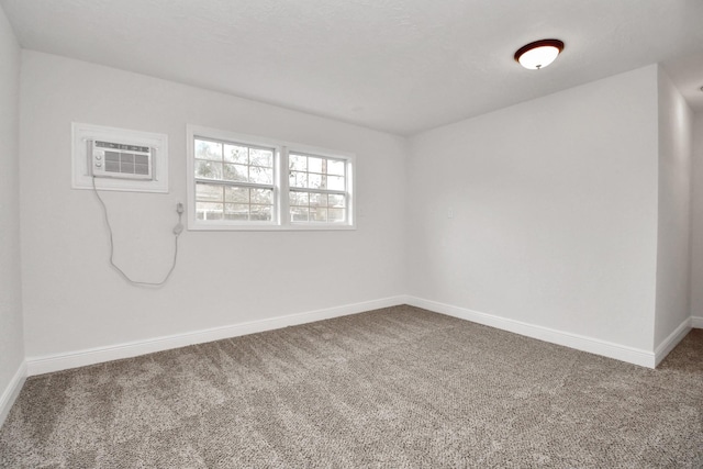 unfurnished room featuring a wall mounted AC and carpet floors