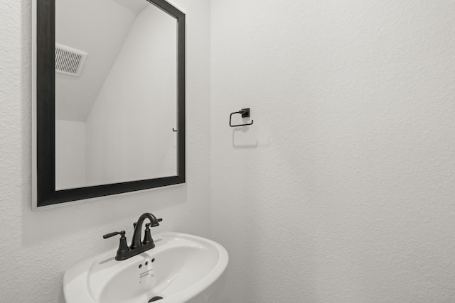 bathroom with vaulted ceiling and sink