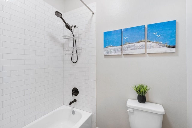 bathroom featuring toilet and tiled shower / bath