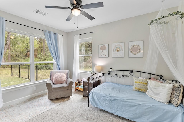 bedroom with multiple windows, ceiling fan, and carpet floors