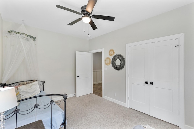 carpeted bedroom with ceiling fan and a closet