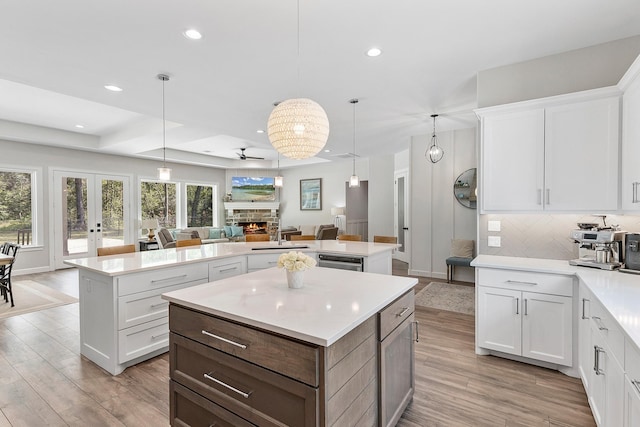 kitchen with ceiling fan, a center island, and white cabinets