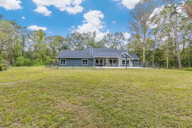 back of house with a lawn and a patio