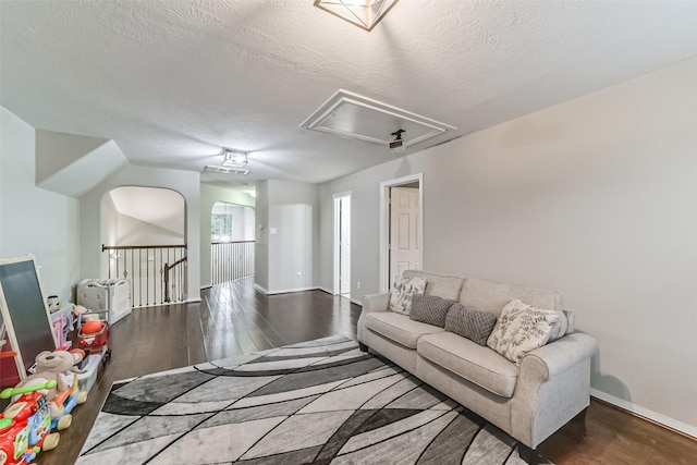 living room with dark wood-type flooring and a textured ceiling