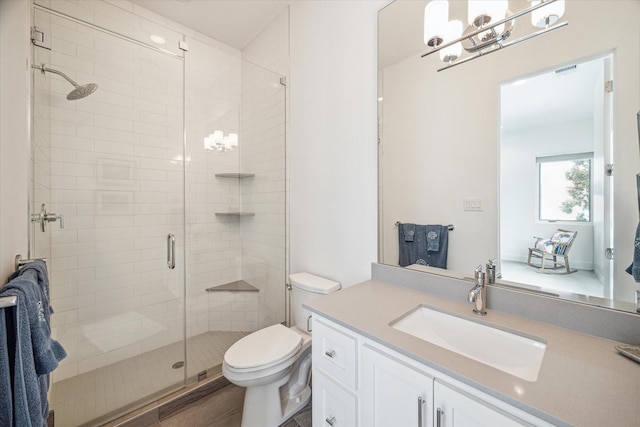 bathroom with hardwood / wood-style flooring, vanity, toilet, and walk in shower