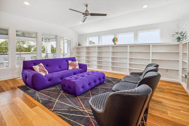 living room featuring a wealth of natural light, ceiling fan, wood-type flooring, and lofted ceiling