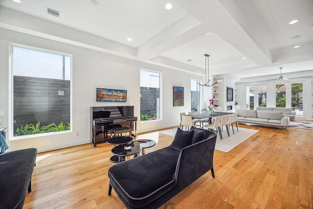 living room with ceiling fan with notable chandelier and light wood-type flooring