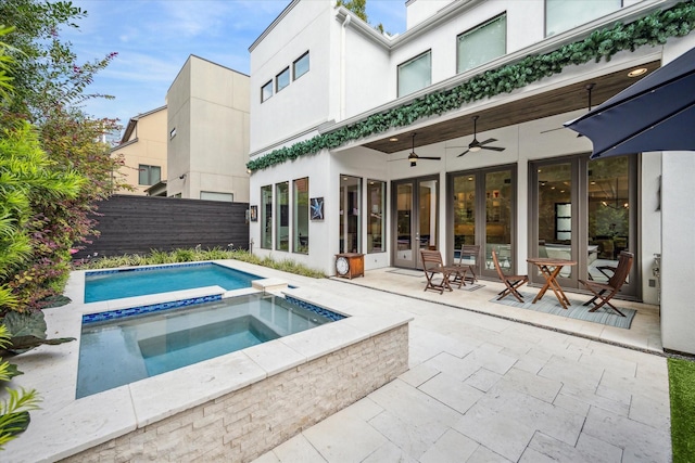 back of house with a swimming pool with hot tub, a patio area, ceiling fan, and french doors