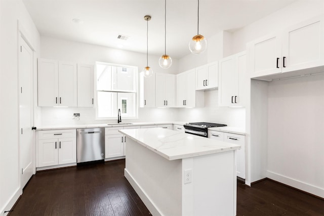 kitchen with a center island, white cabinets, appliances with stainless steel finishes, decorative light fixtures, and light stone counters