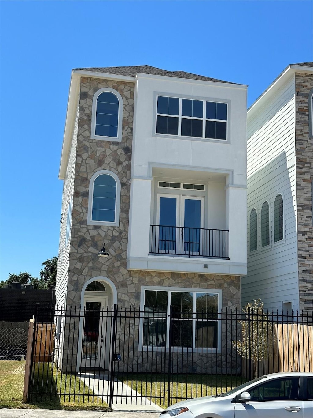 view of front of home featuring a fenced front yard, a gate, a balcony, and stucco siding