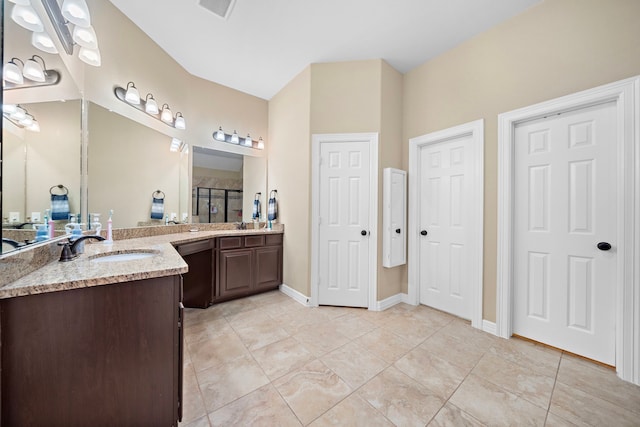 bathroom with tile patterned floors, vanity, and walk in shower