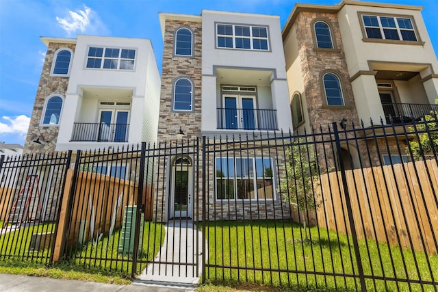 townhome / multi-family property featuring a balcony and a front lawn