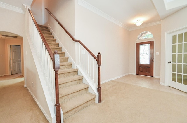 carpeted foyer featuring crown molding