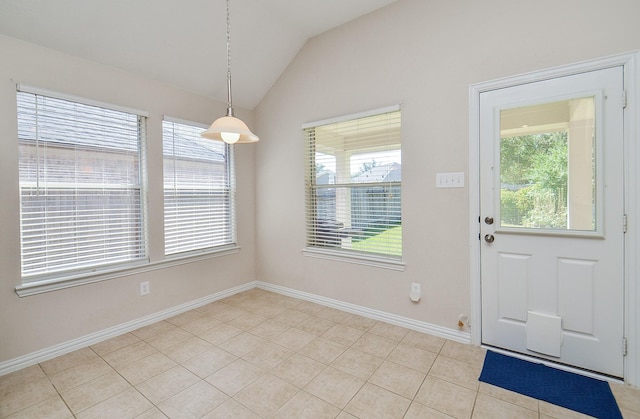 unfurnished dining area with vaulted ceiling, a wealth of natural light, and light tile patterned flooring