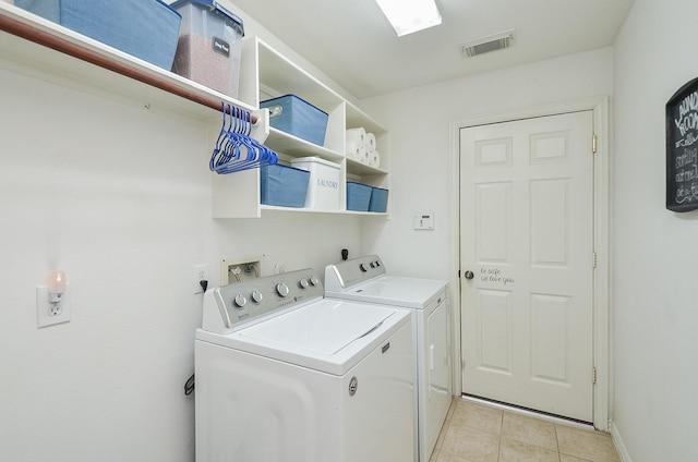 washroom featuring light tile patterned floors and washer and clothes dryer