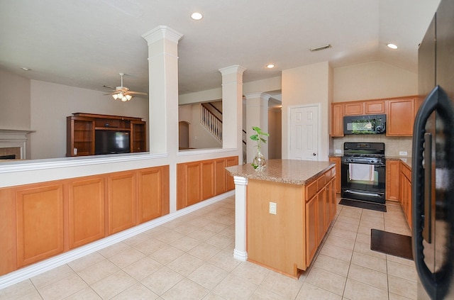 kitchen with a center island, black appliances, vaulted ceiling, ceiling fan, and decorative columns