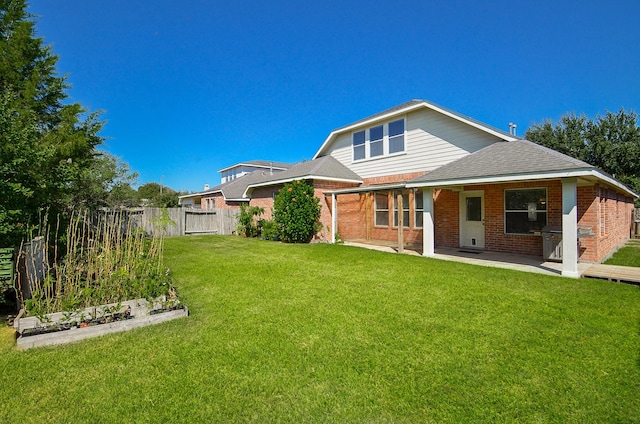 back of house with a yard and a patio