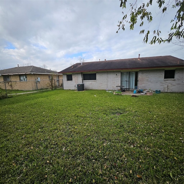 rear view of house with a lawn and central air condition unit