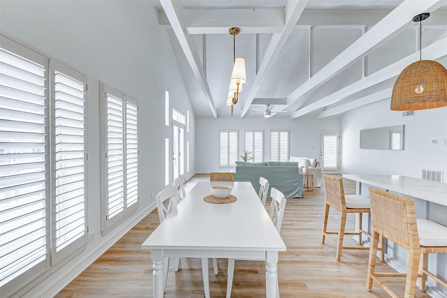 dining space with vaulted ceiling with beams, light hardwood / wood-style floors, and ceiling fan