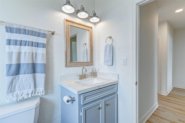 bathroom featuring hardwood / wood-style floors, vanity, and toilet