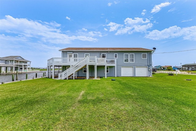 back of property with a deck with water view, a garage, and a lawn