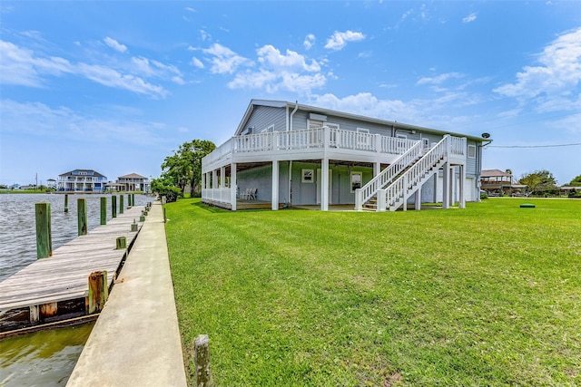 view of dock featuring a lawn and a deck with water view