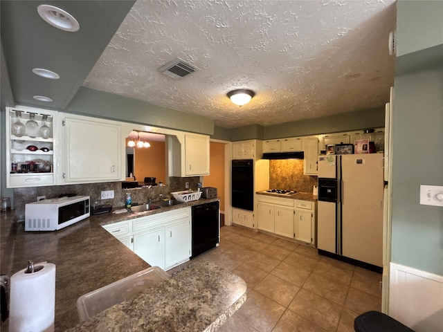 kitchen with backsplash, sink, light tile patterned flooring, and black appliances