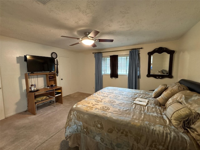 bedroom featuring carpet flooring, ceiling fan, and a textured ceiling