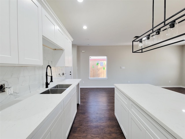 kitchen with backsplash, sink, decorative light fixtures, dark hardwood / wood-style floors, and white cabinetry