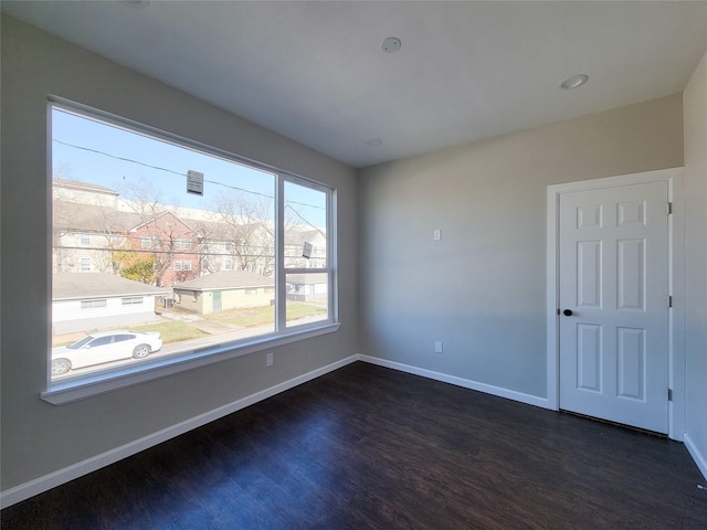 unfurnished room with dark hardwood / wood-style flooring