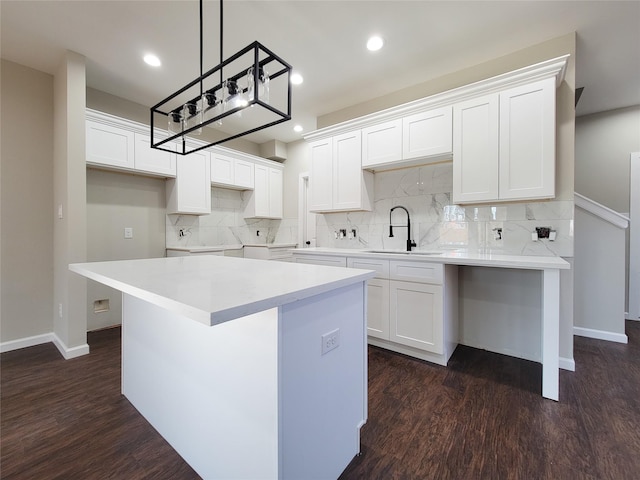 kitchen featuring white cabinetry, sink, and a kitchen island