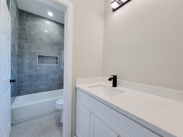 full bathroom featuring vanity, toilet, and tiled shower / bath