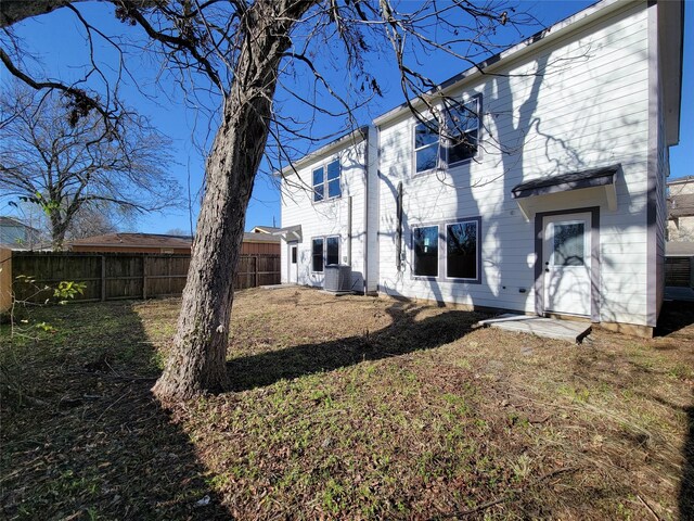 rear view of house featuring a lawn and cooling unit