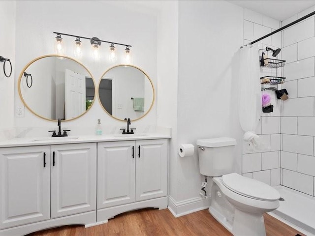 bathroom with hardwood / wood-style floors, vanity, curtained shower, and toilet