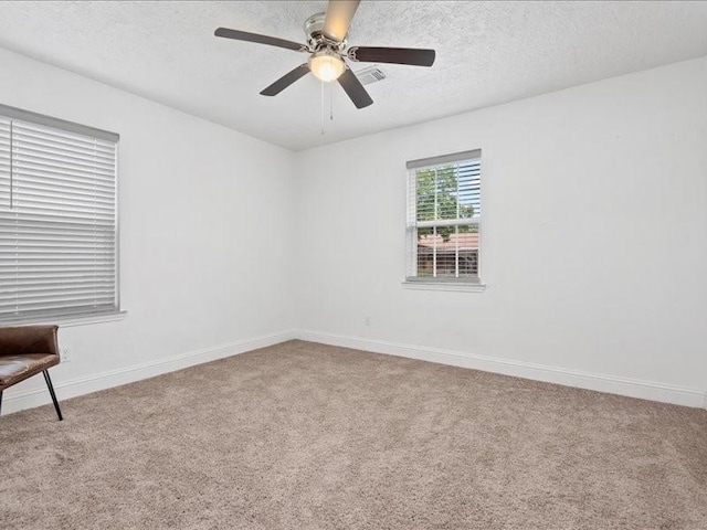 unfurnished room featuring ceiling fan, carpet, and a textured ceiling