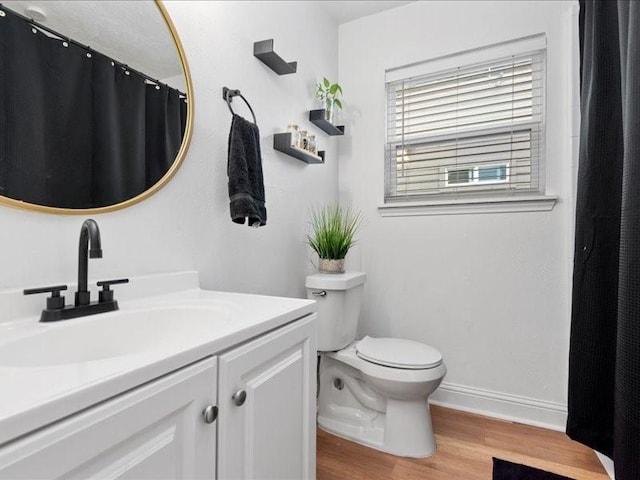 bathroom with hardwood / wood-style floors, vanity, and toilet