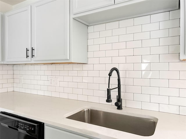 kitchen featuring dishwasher, sink, decorative backsplash, and white cabinets