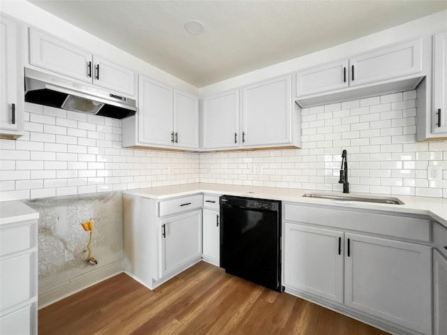 kitchen with sink, dark hardwood / wood-style floors, dishwasher, white cabinets, and backsplash